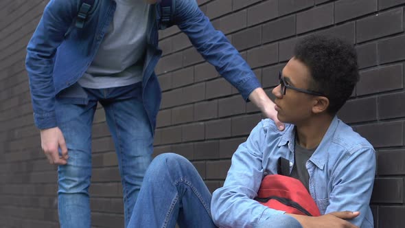 Caucasian Teenager Supporting African-American Student, Touching His Shoulder