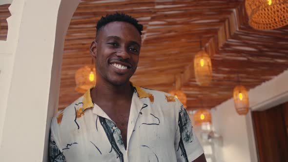 AfricanAmerican Man Smiles While Standing in a Coffee Shop