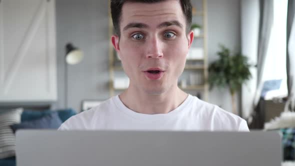 Close Up of Excited Man Celebrating Success on Laptop