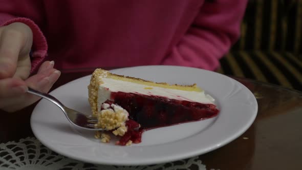 Girl Eats Raspberry Cheesecake In Cafe