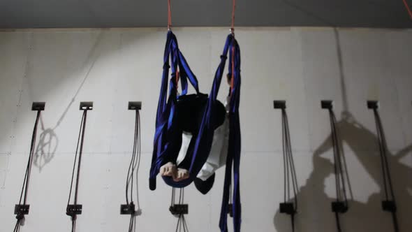 A Young Woman in Hijab Does Aerial Yoga