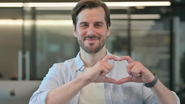 Portrait of Man Showing Heart Sign By Hand