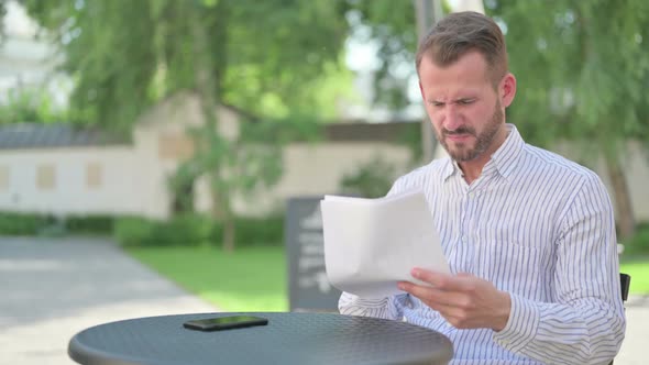 Middle Aged Man Upset While Reading Documents