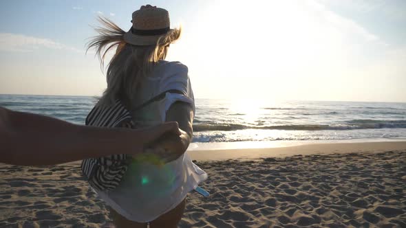 Follow Me Shot of Young Woman in Shirt with Backpack Pull Her Boyfriend to the Shore