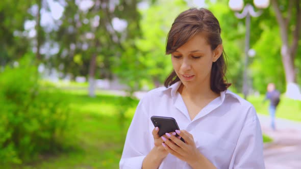 Young Businesswoman Chatting Online Use Cellphone Stroll in Park