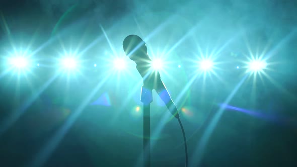 Closeup of Microphone on Stage in the Dark on a Black Smoky Background