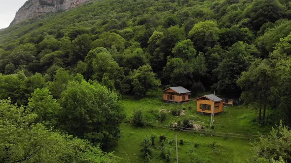 Aerial View Among the Green Forests Stand Two Wooden Buildings