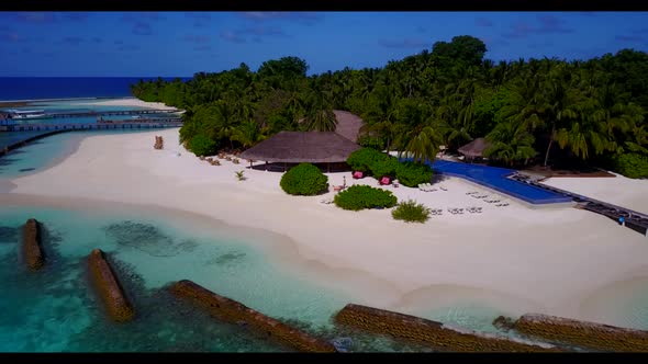 Aerial drone shot landscape of exotic coastline beach break by blue lagoon with white sand backgroun