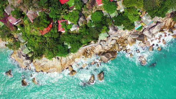 Beautiful flying tourism shot of a white paradise beach and aqua blue ocean background in vibrant 4K