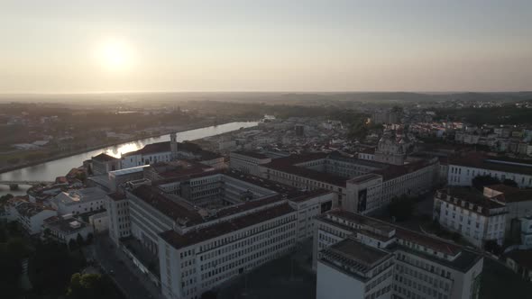 Historical buildings of University of Coimbra against Mondego River and beautiful sunset