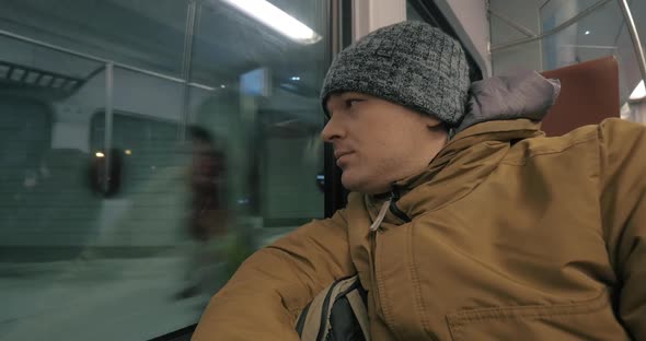 Commuter Man Traveling By Train in Winter Evening