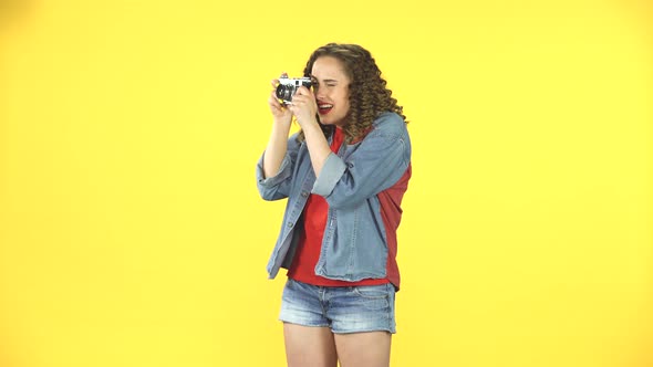 Smiling Girl Is Shooting Pictures on a Retro Photo Film Camera. Retro Style Vintage Picture Woman