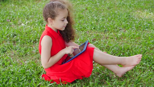 Curious Cute Girl Preschool Child Using a Digital Tablet Technology Device Looks Telephone Sitting