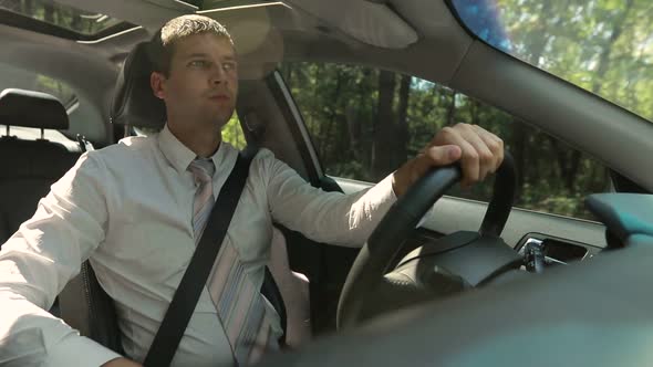 Handsome Serious Man Driving Car on Rural Road