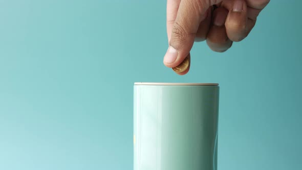 Young Man Saving Coins in a Jar with Copy Space