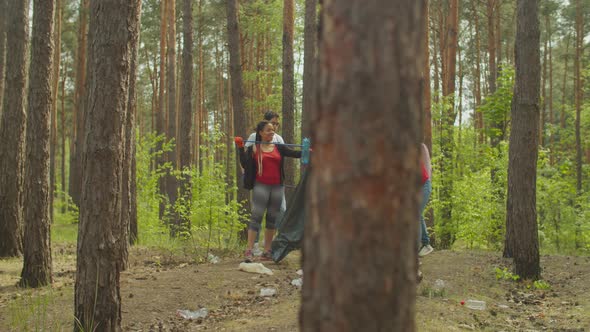 Multiethnic Volunteers Cleaning Litter in Forest