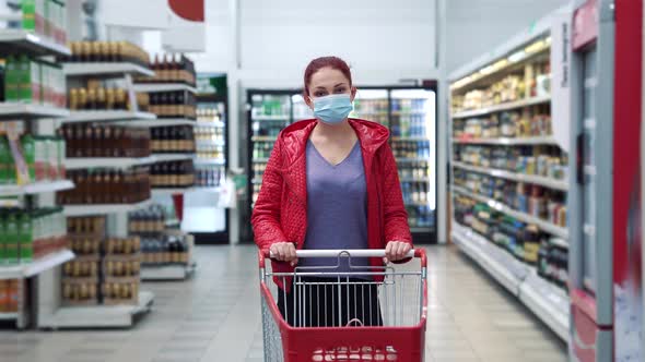 Woman with shopping cart in supermarket during pandemic