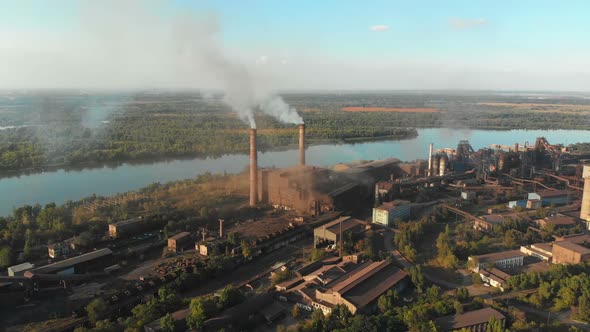 Aerial View of the Industrial Plant with Smoking Pipes Near the City. Industrial Zone