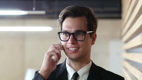 Young Businessman Talking on Phone, Discussing Project, Portrait