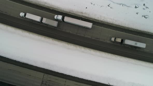 Trucks Driving Ice Cold Snowy Road Aerial alt