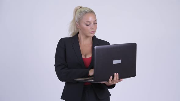 Young Happy Blonde Businesswoman Thinking While Using Laptop