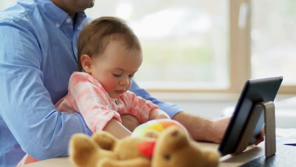 Father with Baby Working on Tablet Pc at Home