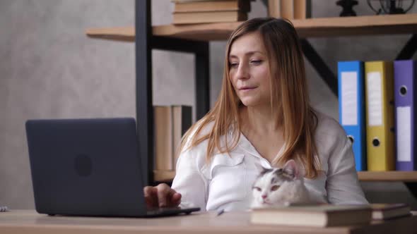 Pensive Adult Woman with Cat During Work at Home