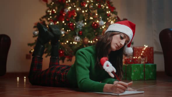 Girl write Dear Santa letter for Christmas