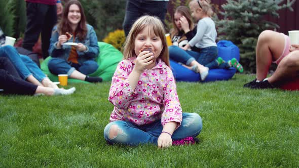  Little Girl Eating a Hot Dog in the Backyard