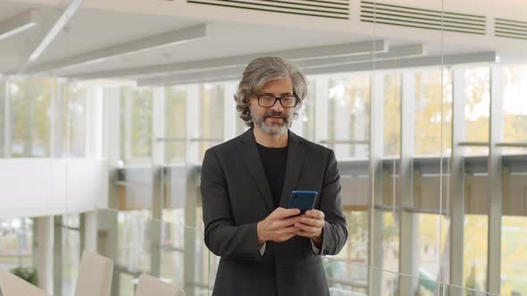 Portrait Of Smiling Businessman With Smartphone