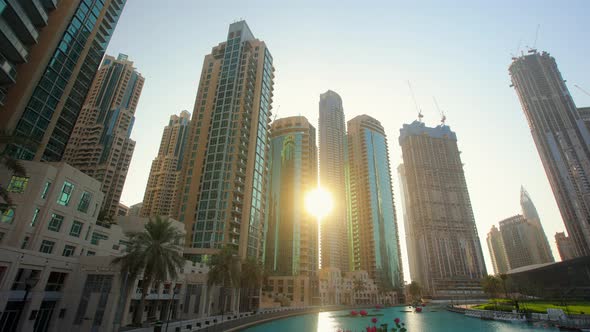 Downtown City with Skyscrapers Through Which the Sun Breaks Through at Sunset