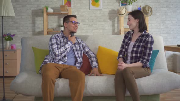 a Man Communicates with a Young Woman Sitting on the Couch Uses Speech Aid