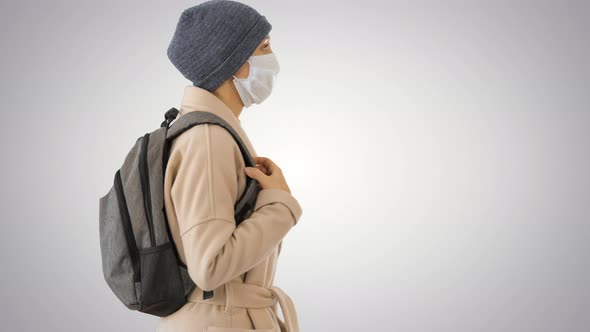 Covid-19 Virus Prevention, Woman Wearing a Medical Mask on Her Face Walking on Gradient Background.