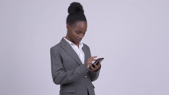 Young African Businesswoman Using Phone and Looking Shocked