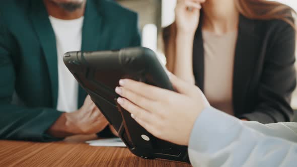 Hands Holding Tablet Computer with Blurred Background of African Man and