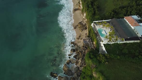 Beautiful Bingin beach with exotic cliffs houses and hotel located in Bali, Indonesia. This drone fo