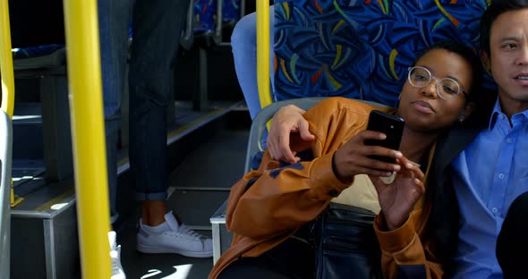 Couple using mobile phone while travelling in bus 4k