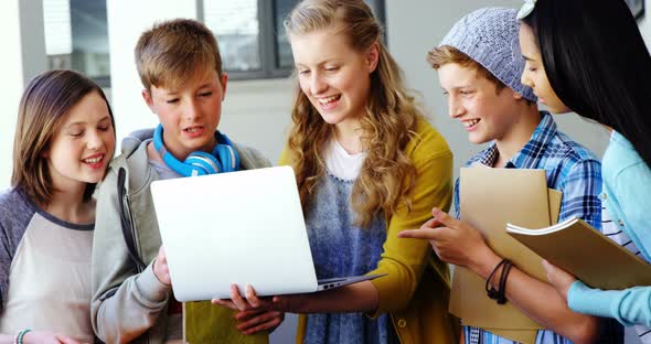 Group of students using laptop in classroom