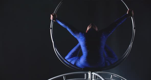 Woman is Balancing in a Big Spinning Hoop Gymnastics Show in the Studio