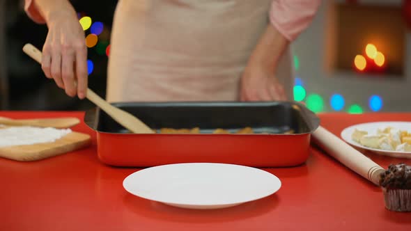 Woman Serving Traditional Christmas Cookies on Plate, Lights Sparkling on Tree