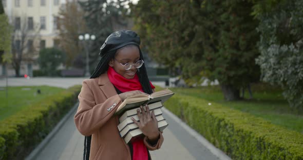 Young Black Female Student Holding Many Books in Her Hands