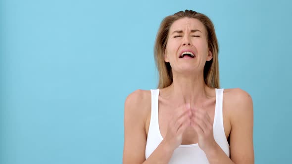 Blonde Model Sneezing while Covering Her Mouth With both Her Hands