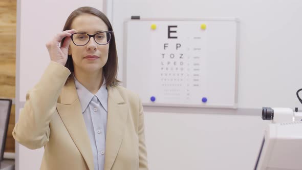 Positive Woman in Glasses Posing for Camera in Ophthalmology Clinic