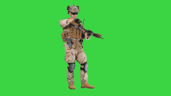 Soldier in Camouflage Gear Checking His Uniform and Ammunition on a Green Screen, Chroma Key.