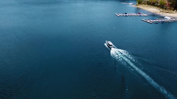 A drone flies over the boat sailing in the lake, aerial view of Lake Arrowhead, California, USA