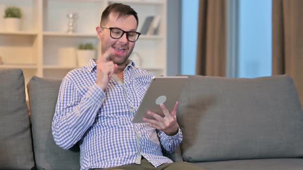 Excited Young Man Doing Video Call on Tablet at Home 