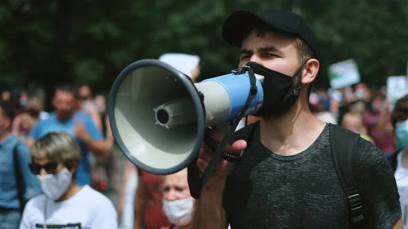 Pandemic Restrictions Coronavirus Protests Man with Megaphone Bullhorn Shouts