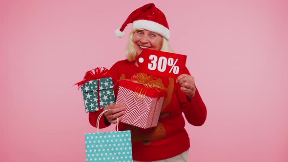 Senior Woman in Christmas Sweater Showing Gift Box and 30 Percent Discount Inscriptions Banner Text