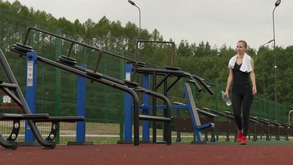 Sporty Woman Walks on the Sports Field Outside