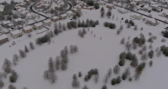 Snowfall Over Small Town Residential with Snow Covered Roofs Houses in USA Countryside
